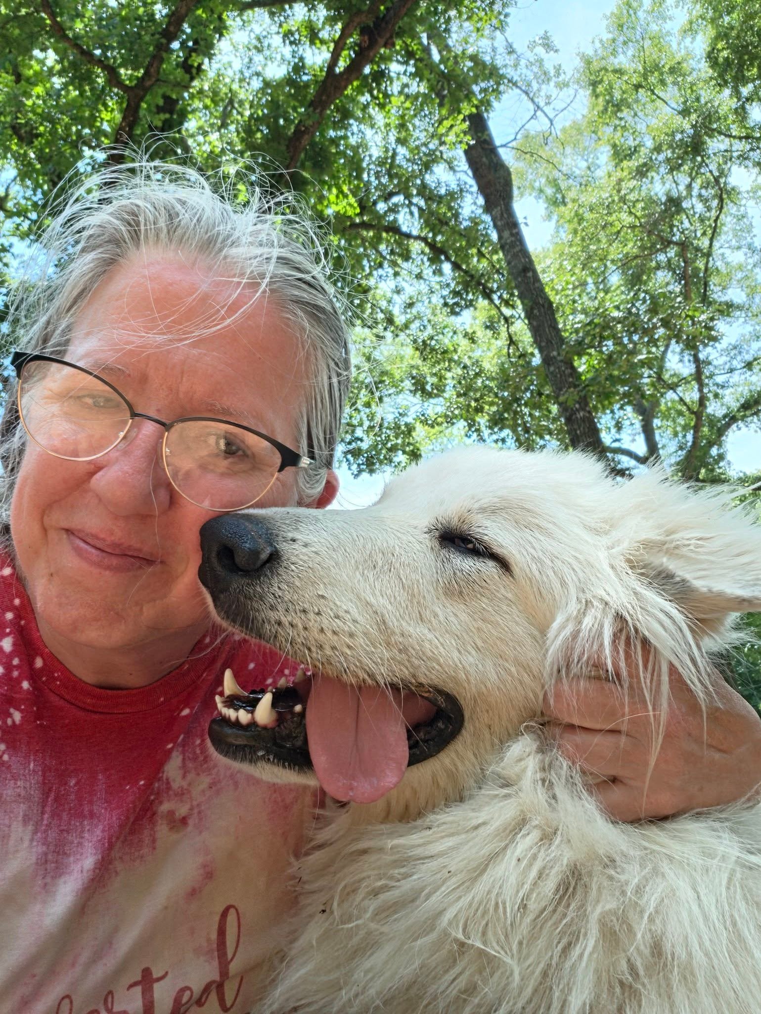 Virginia McQuiston smiling beside a white dog